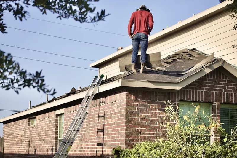 Professional roofer working on a residential roof in Ewansville